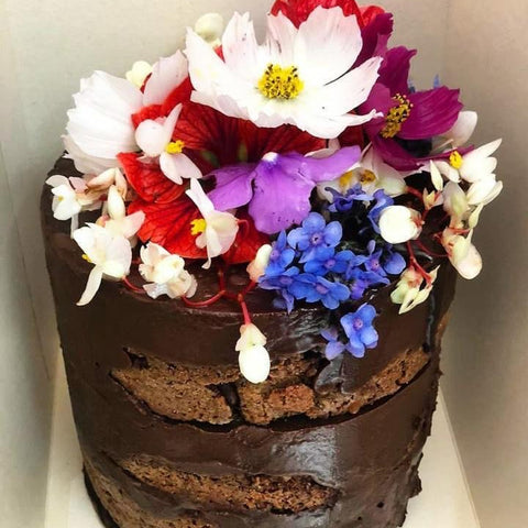 Torta de chocolate sin harina con almendras en torre con flores comestibles